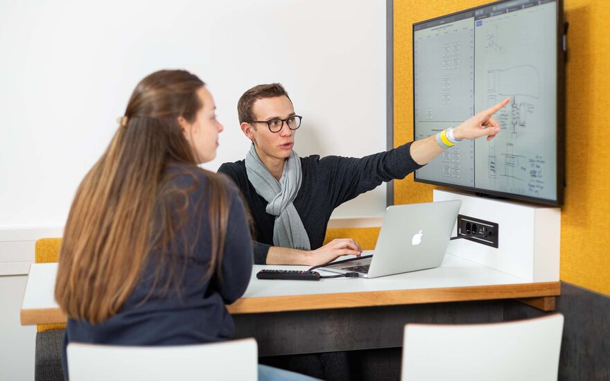 Zwei Studierende arbeiten in einer Gruppe mithilfe eines Screens.