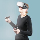 Eine Frau mit VR-Brille und Joysticks.