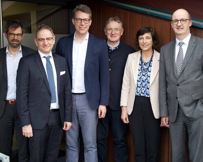 Staatsminister Blume steht in der Mitte, umgeben von fünf weiteren Personen aus Politik, Hochschule und Wirtschaft