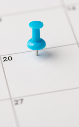 Kalender, auf dem eine Pinnnadel steckt.