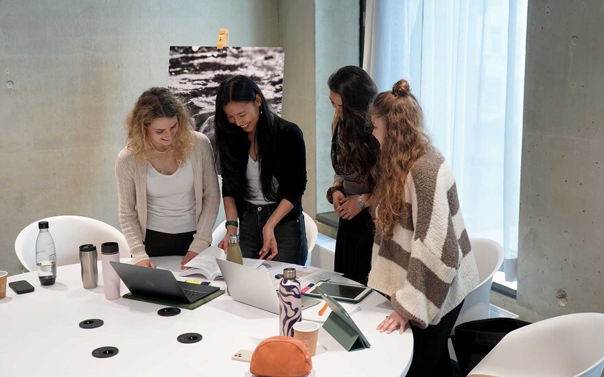 4 Studentinnen arbeiten gemeinsam an einer Gruppenarbeit.