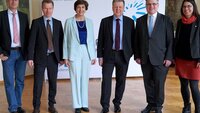 Die Hochschulleitung mit den beiden Landtagsabgeordneten vor der weißen Wand mit dem TH-Logo im Hocksaal