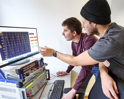 Zwei Doktoranden im Labor für Elektrische Maschinen, Leistungselektronik und Antriebe.