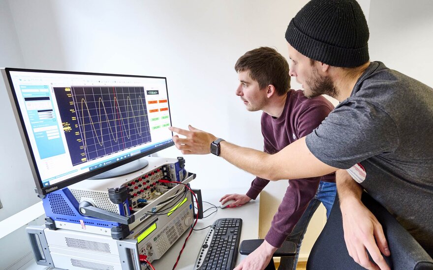 Zwei Doktoranden im Labor für Elektrische Maschinen, Leistungselektronik und Antriebe.