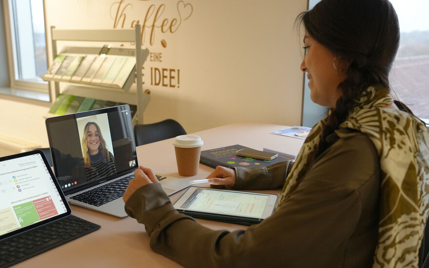 Eine Studentin bespricht über Videochat mit einer Kommilitonin ihre Gruppenarbeit