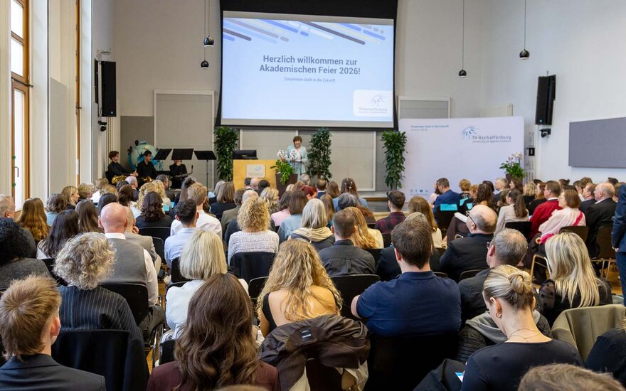 Blick auf die gefüllten Sitzplätze der Aula mit Präsidentin am Rednerpult