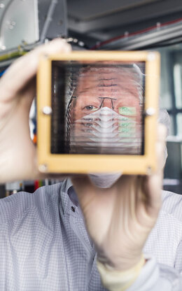 Der Laborleiter des Labors für Beschichtungstechnik schaut durch das Lobster Eye X-ray Telescope.