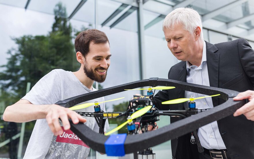 Ein Professor und ein Studierender mit einer Drohne.