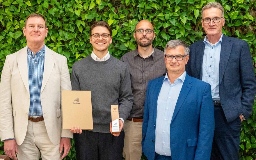 Fünf Personen, zweite Person hält Preis in der Hand