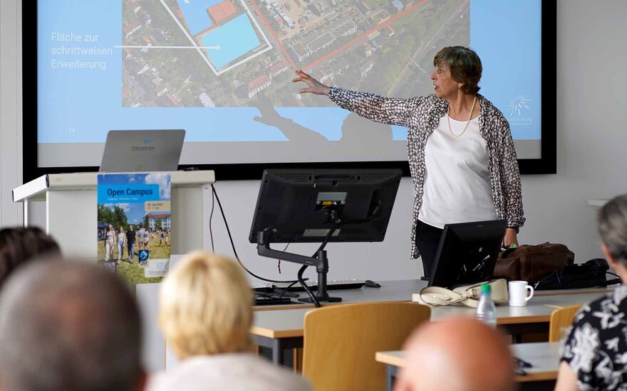 Präsidentin zeigt auf Leinwand dem Stadtrat im Hörsaal das TVA-Gelände
