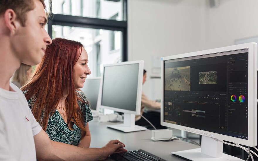 Zwei Studierende arbeiten in einem Bild-Bearbeitungsprogramm.