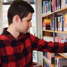 Student greift in Bücherregal in Bibliothek 