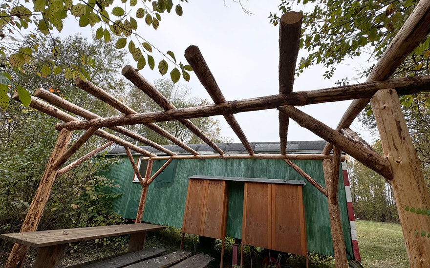 Pergola neben einem Bauwagen mit der Aufschrift Forscherwagen