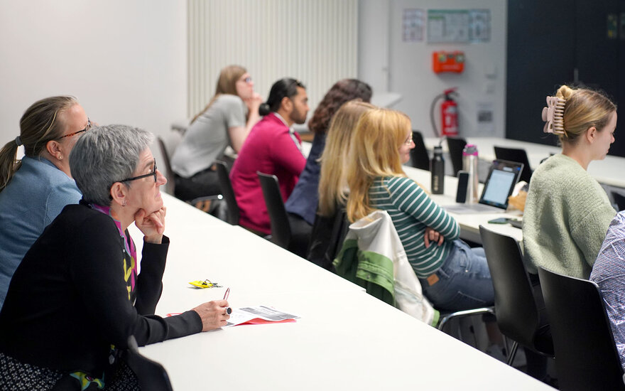 Professor Balleis and other guests listen to a speech