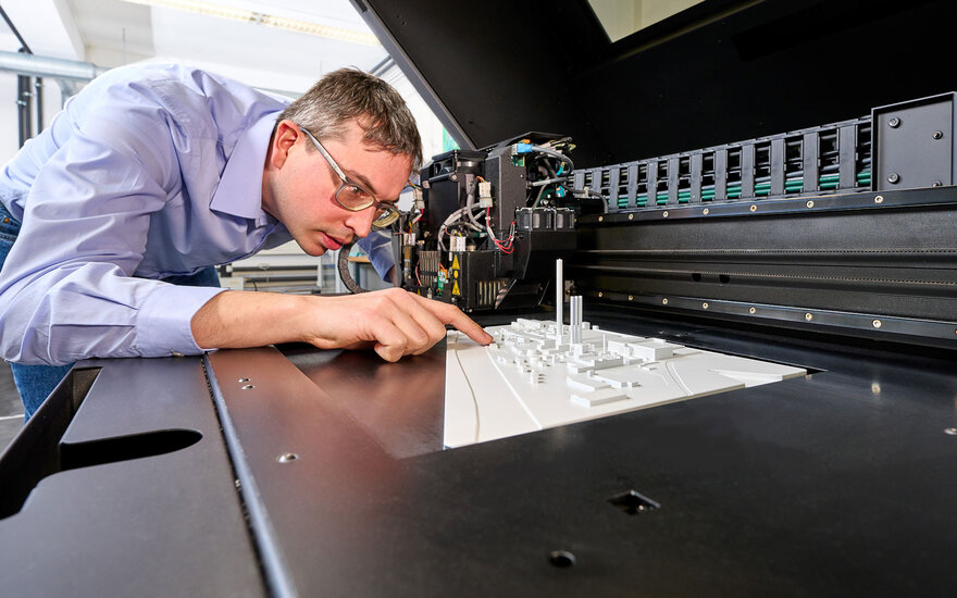 Ein Mitarbeiter der Forschungseinrichtung ZeWiS an einem 3D-Drucker.