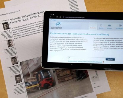 Fachzeitschrift, auf der ein Tablet liegt