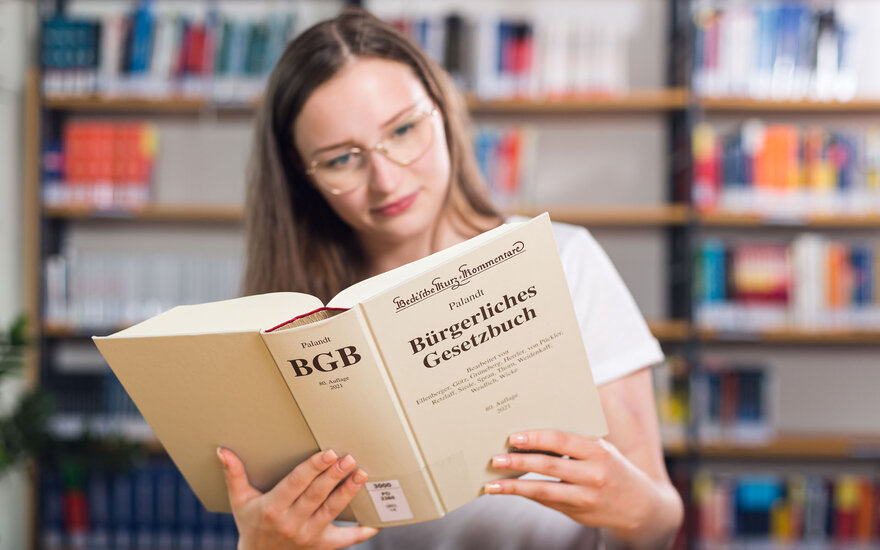 Studentin liest in BGB in der Bibliothek