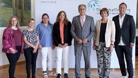 Fünf Frauen und zwei Männer stehen nebeneinander vor weißer Messewand mit blauem TH-Logo im Hocksaal