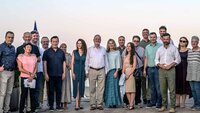 Gruppenfoto mit zwanzig nebeneinanderstehenden Personen im Freien 