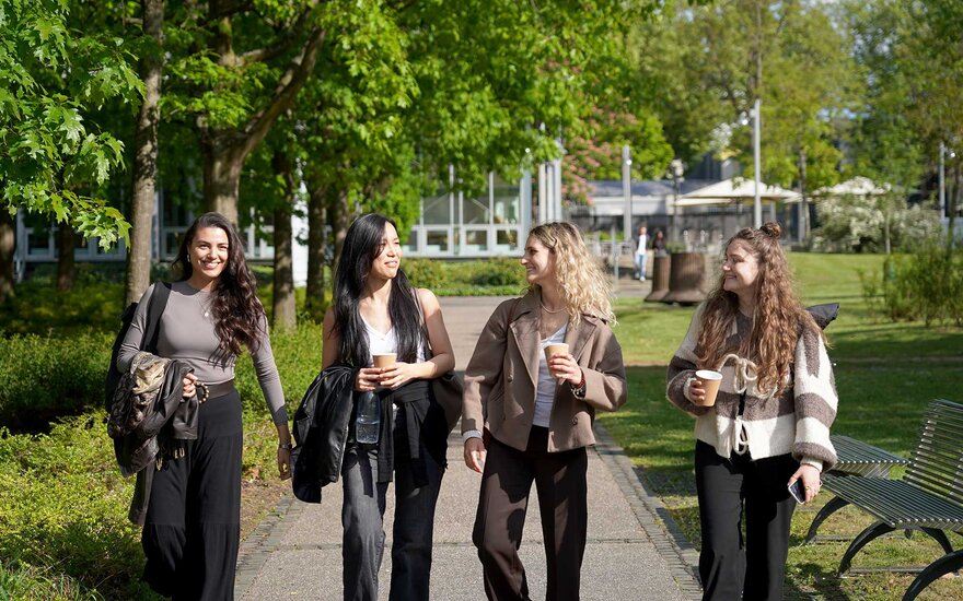 Vier Studentinnen laufen über den Campus.