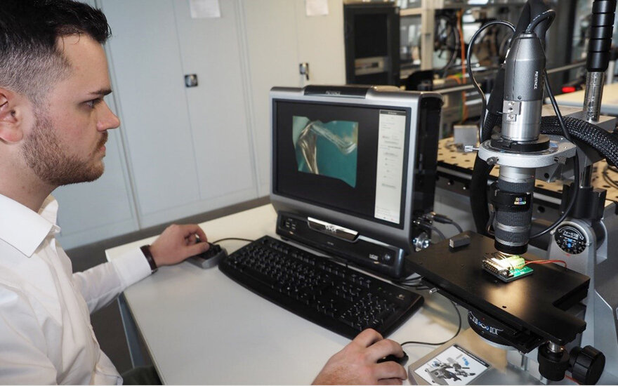Ein Student an einem Digitalmikroskop.