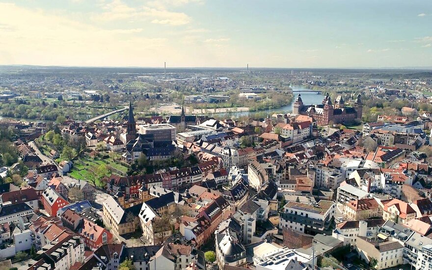 Die Stadt Aschaffenburg aus der Vogelperspektive. Zu sehen sind das historische Schloss Johannisburg, Stiftskirche und Rathaus, Altstadt, Teile der Neustadt und der Main.
