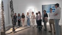 Studierende stehen im Halbkreis mit Präsidentin vor einem Kunstwerk