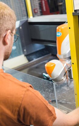 Ein Student definiert die Schneidegröße für die Wasserstrahlschneidanlage des Labors für Produktionstechnik.