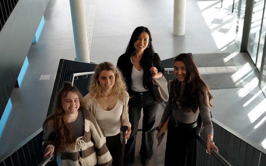 Vier Studentinnen in einem Treppenhaus auf einem Gruppenfoto.