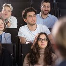 Mehrere Studierende in einem Hörsaal während einer Vorlesung in Frontalansicht