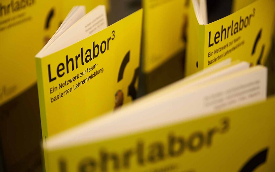 Gelbe Broschüren mit schwarzer Aufschrift zum Lehrlabor