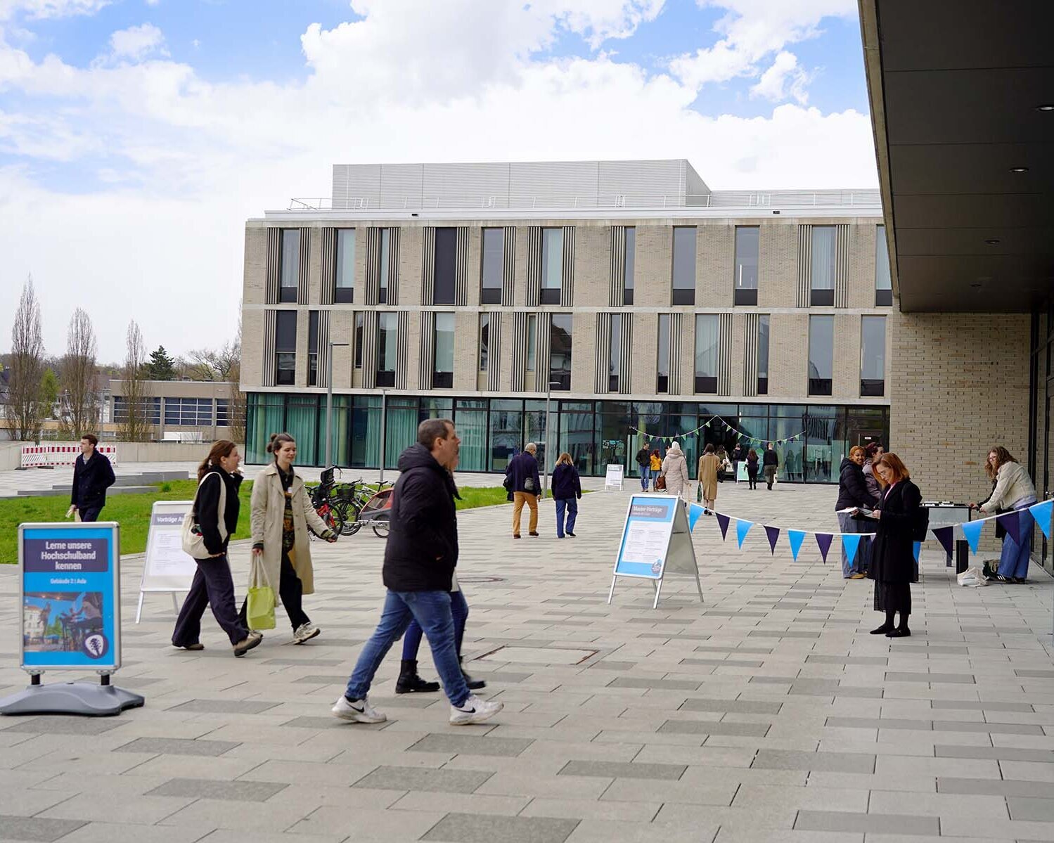 Personen laufen auf die Eingänge der neuen Gebäude zu 
