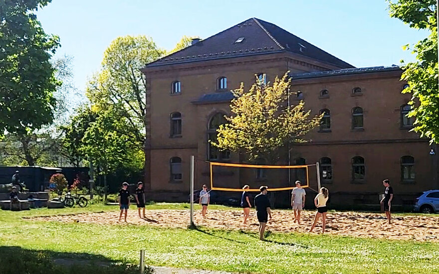 Ein Volleyballfeld und Studierende, die Volleyball spielen
