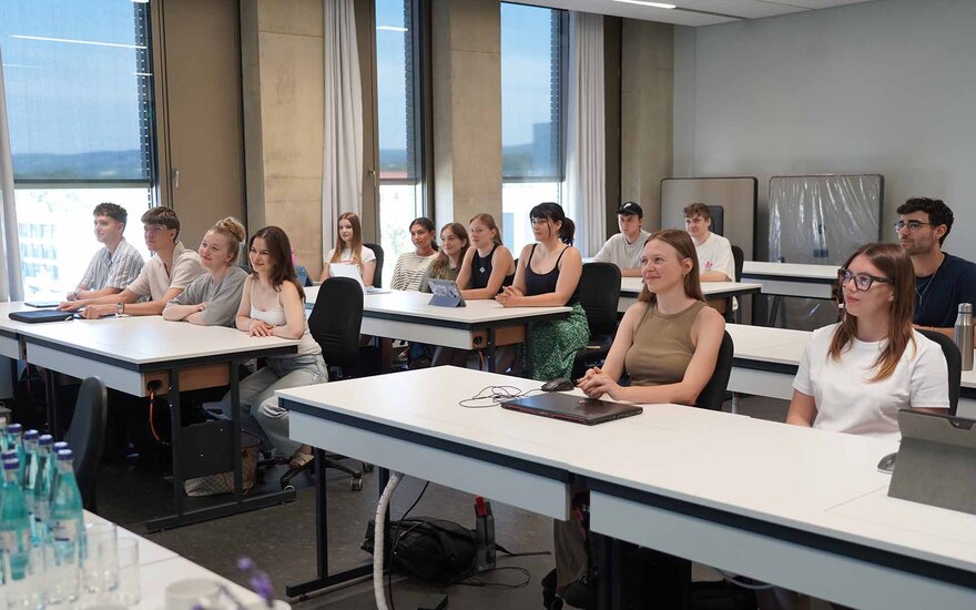 Studierende sitzen in mehreren Tischreihen hintereinander im Labor