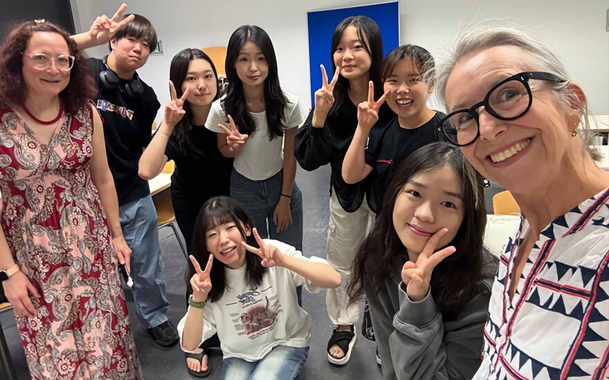 Gruppenfoto mit neun Personen, einige Studierende zeigen ein Peace-Zeichen