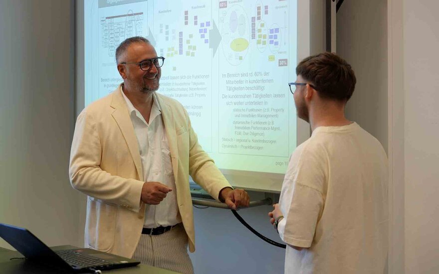 Professor im Gespräch mit einem Studenten
