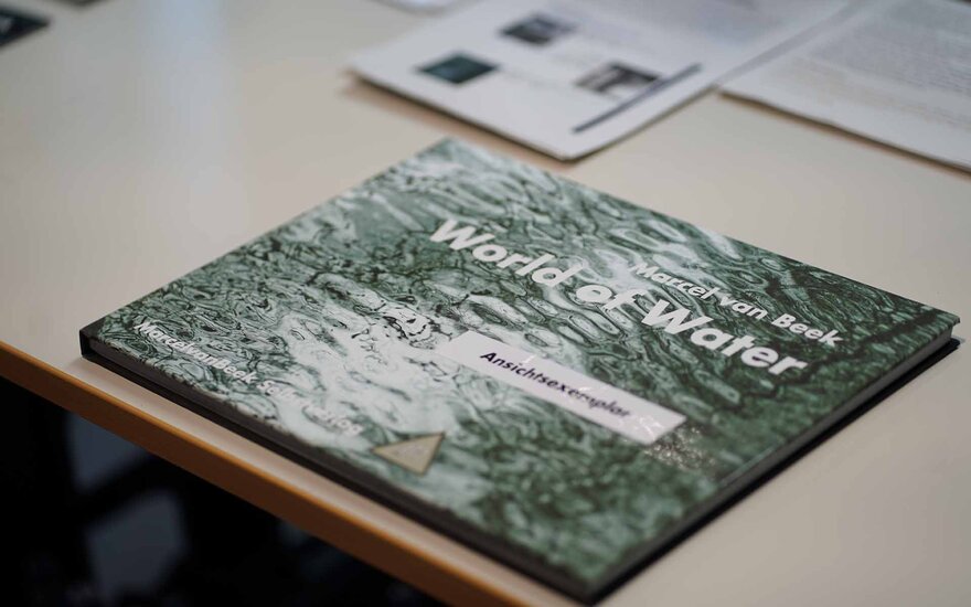 Der Katalog zur Ausstellung liegt auf einem Tisch mit weiteren Infomaterialien