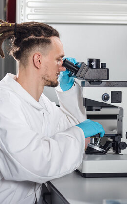 Ein Labormitarbeiter des BioMEMS Lab schaut durch ein Mikroskop.