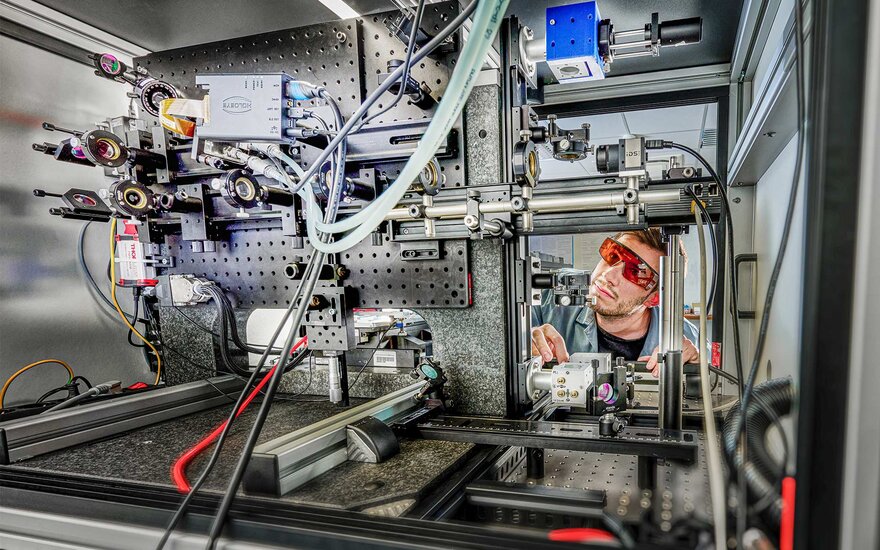 Ein Mitarbeiter konzipiert die Laserstrahlführung für die Materialbearbeitung am ZeWiS.