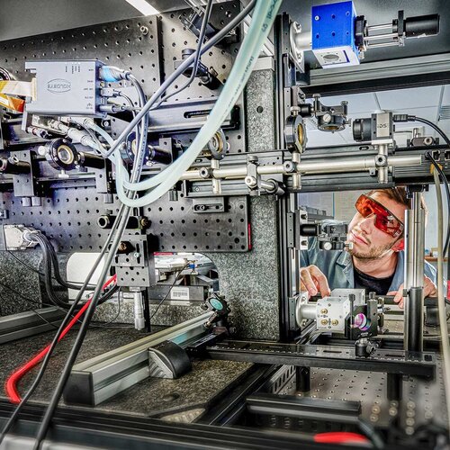 Ein Mitarbeiter konzipiert die Laserstrahlführung für die Materialbearbeitung am ZeWiS.