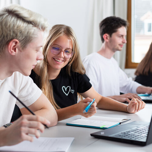 Vier Studierende in Seminarraum mit Laptop