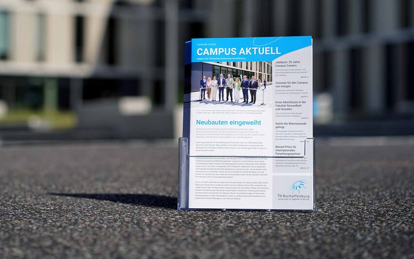 Hochschulmagazine im Prospektständer auf Campus vor Neubauten