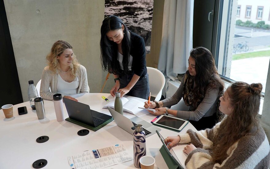 4 Studentinnen arbeiten gemeinsam an einer Gruppenarbeit.