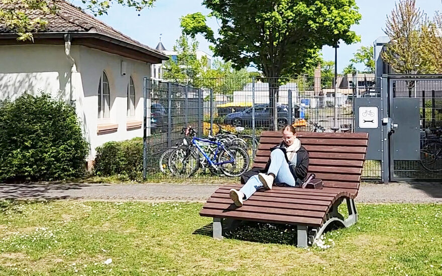 Studentin auf einer Bank im Freien