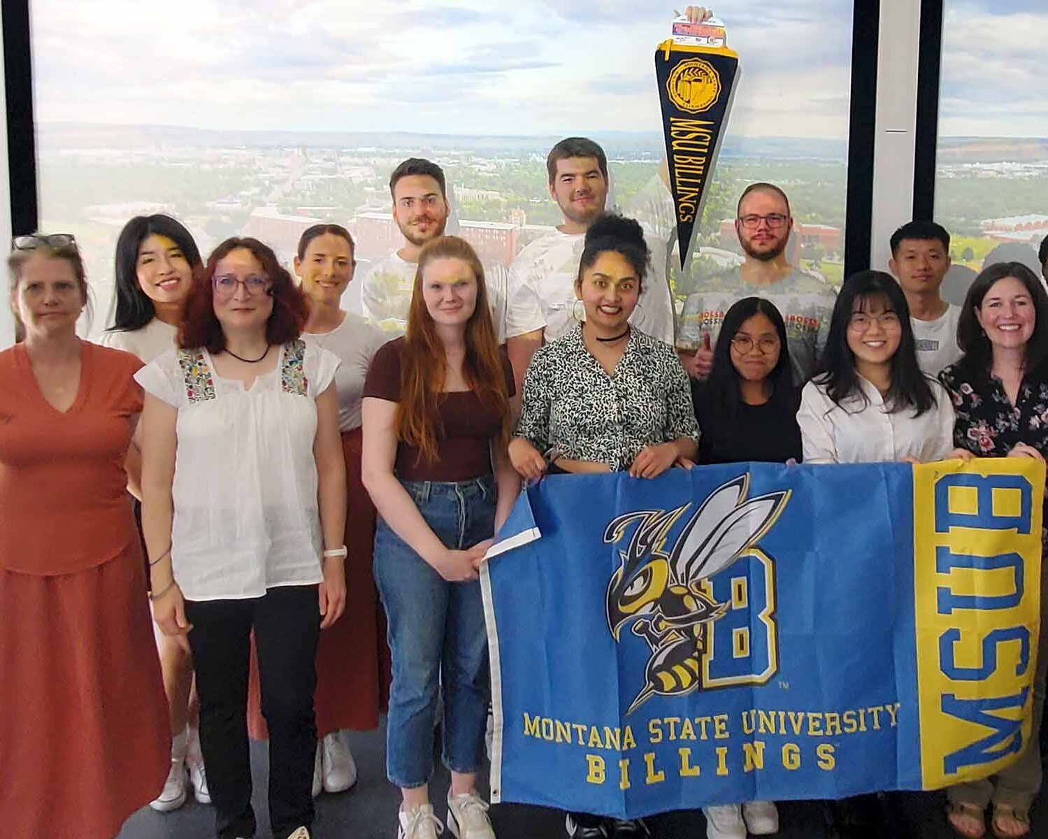 Gruppenfoto mit Gastprofessorinnen, Studierenden und blau-gelber Flagge der Montana State University 