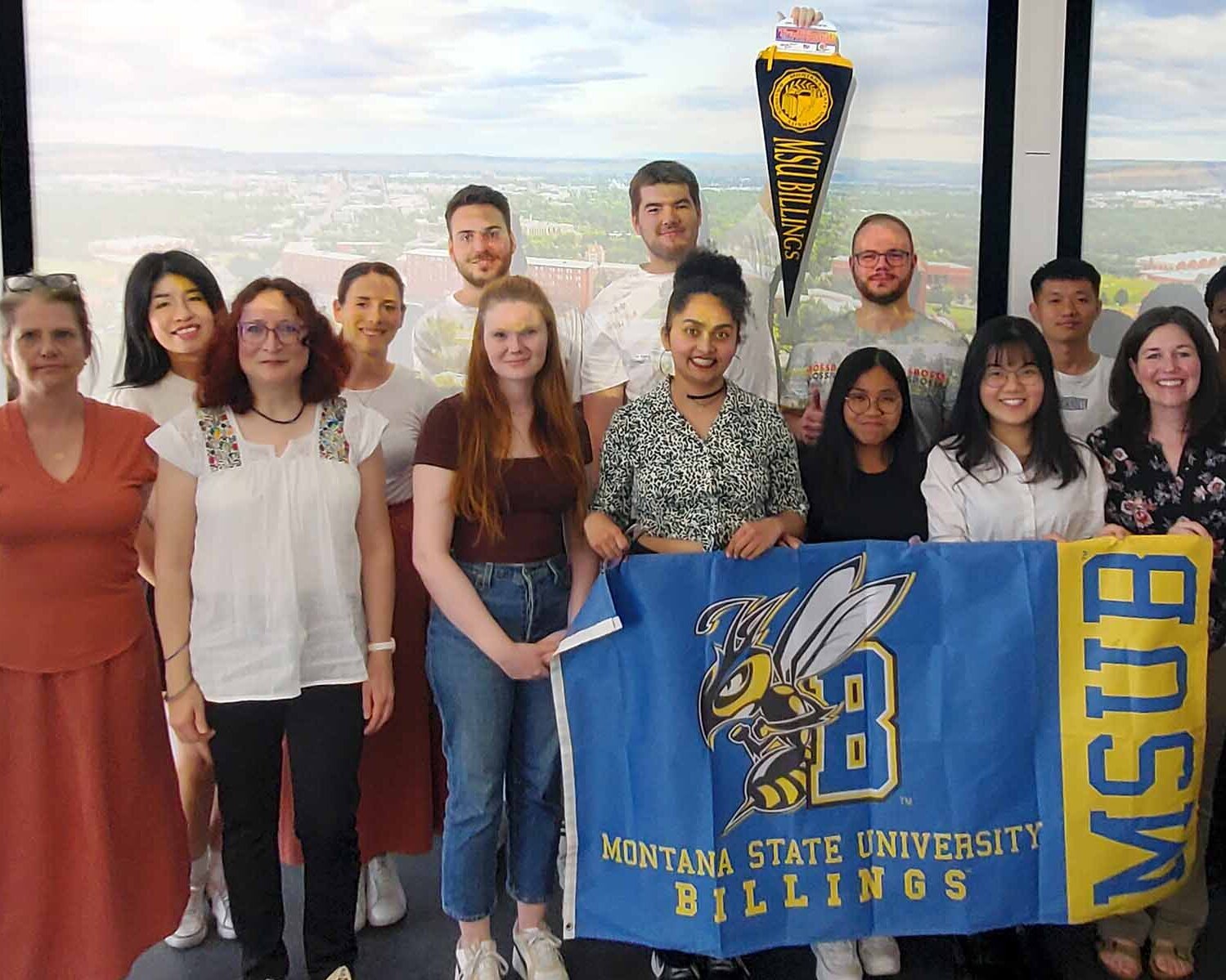 Gruppenfoto mit Gastprofessorinnen, Studierenden und blau-gelber Flagge der Montana State University 