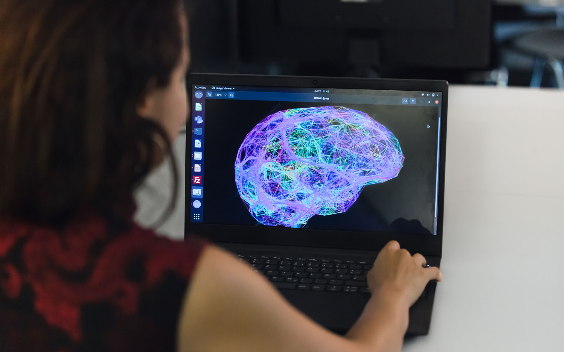 Doktorandin bei der Betrachtung der digitalen Abbildung eines Gehirns am Bildschirm.