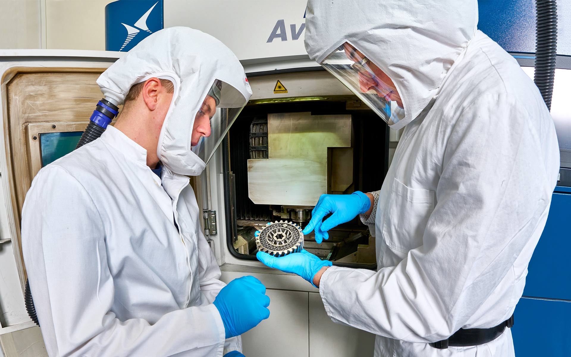 ZeWiS employees during the inspection of the metallic workpiece from the hybrid 3D printing manufacturing process.